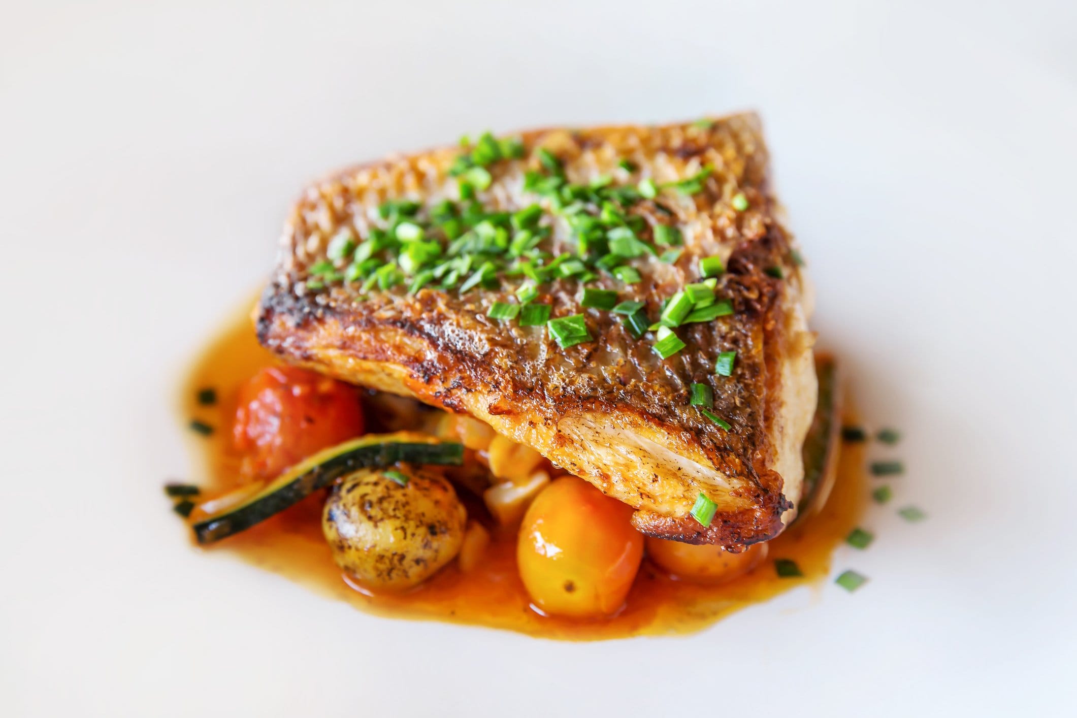 Artfully plated dinner course with seasonal vegetables and garnish