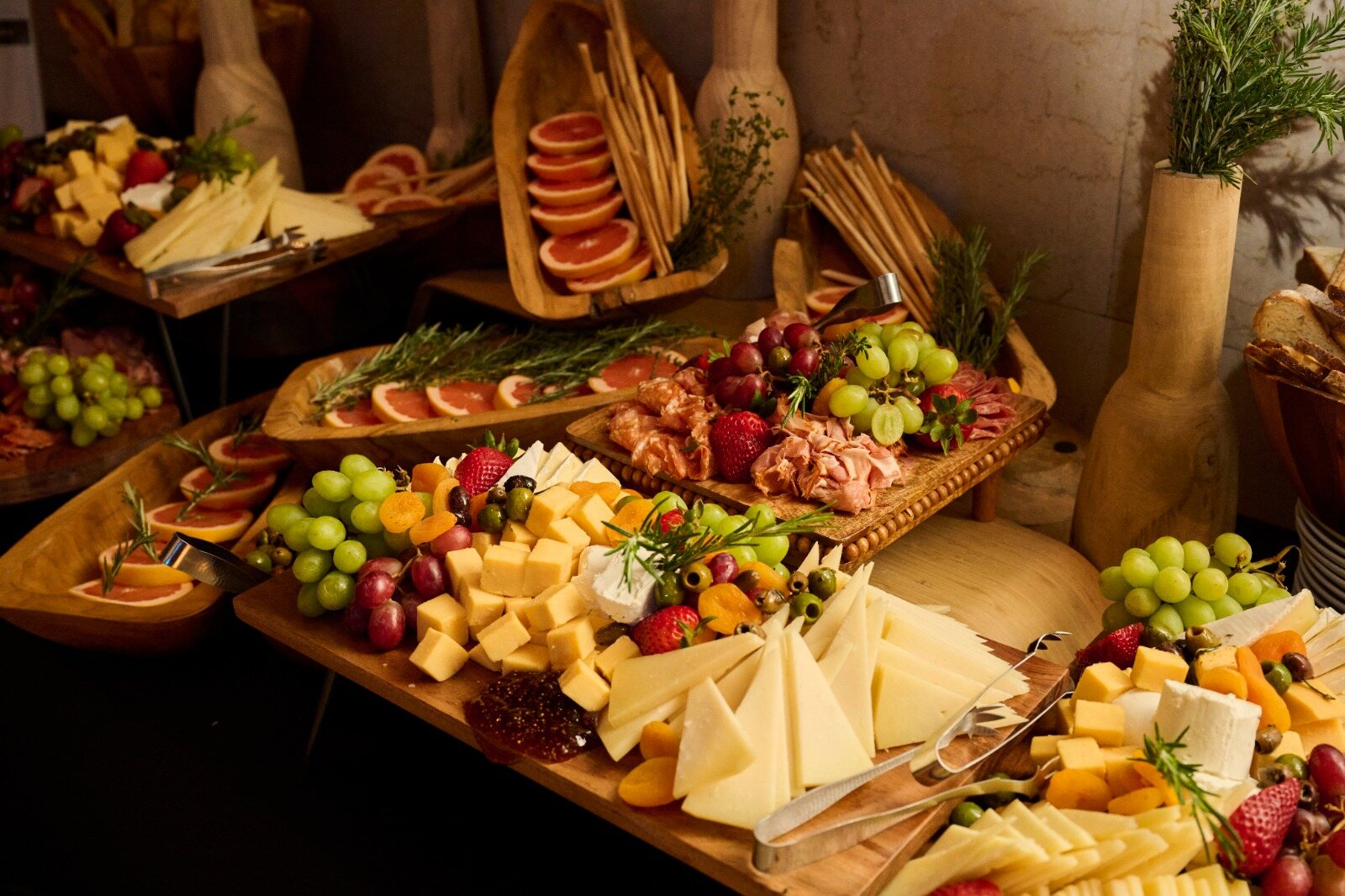 Charcuterie and cheese station with fresh fruit on wooden serving boards