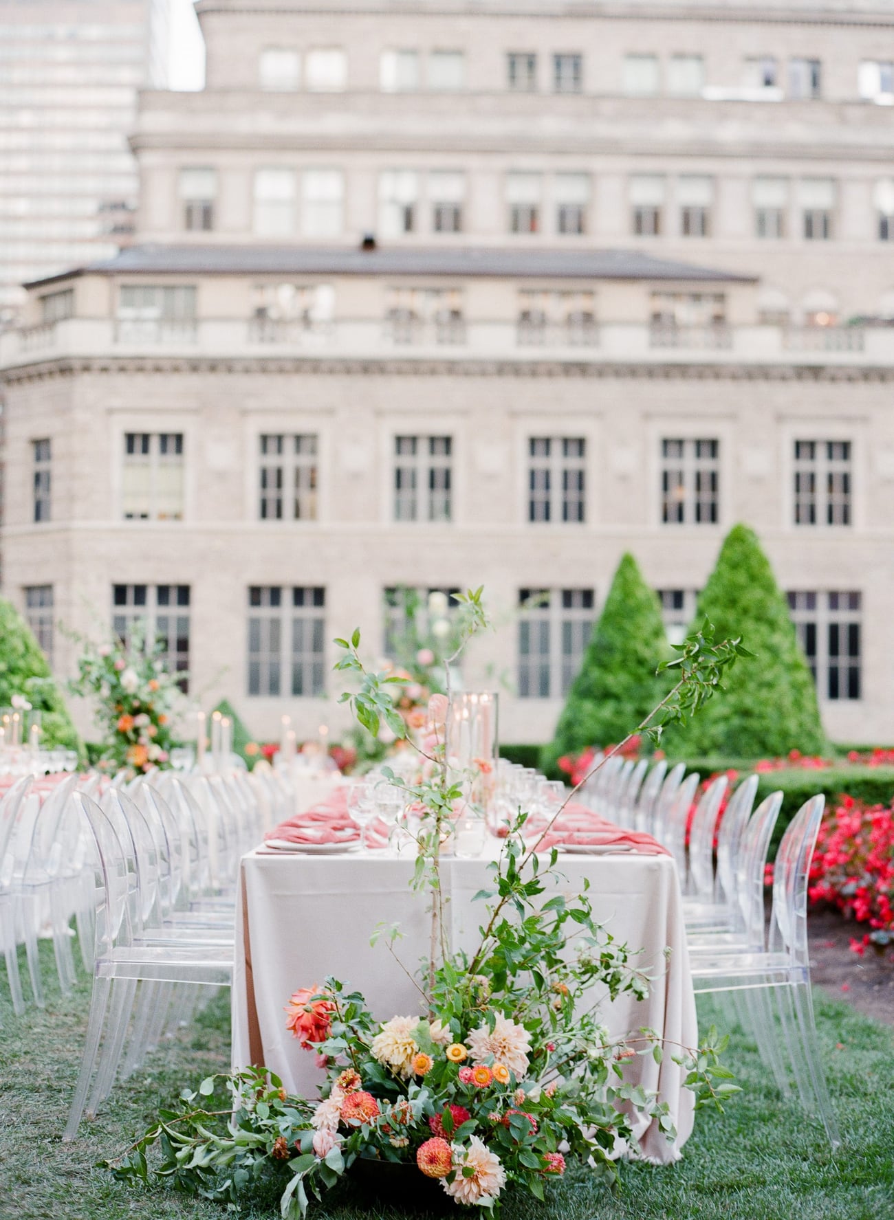 Wedding tablescape with coral florals and a New York City building behind